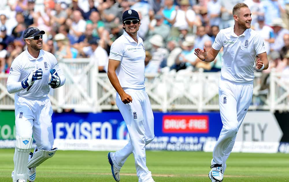 England's Stuart Broad, right, celebrates with Alastair Cook and Matt Prior, left, after bowling India's Virat Kohli, caught by Ian Bell for one run, during day one of the first Test cricket match between England and India at Trent Bridge cricket ground.