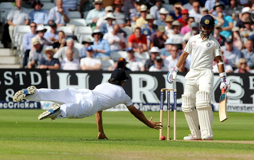 England's Alastair Cook dives but fails to catch India's Ajinkya Rahane, right. A few balls later Alastair Cook caught Ajinkya Rahane bowled by England's Liam Plunkett for 32 runs during day one of the first Test between England and India at Trent Bridge cricket ground, Nottingham.