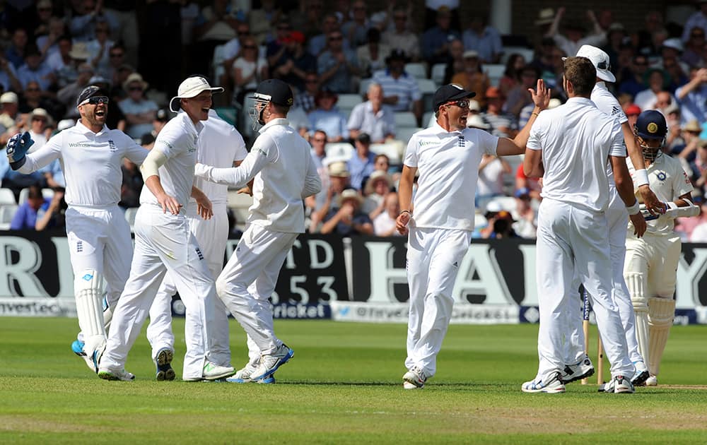 England players celebrate after India's Ajinkya Rahane, right, is bowled by Liam Plunkett caught Alastair Cook for 32 runs during day one of the first Test between England and India at Trent Bridge cricket ground, Nottingham.