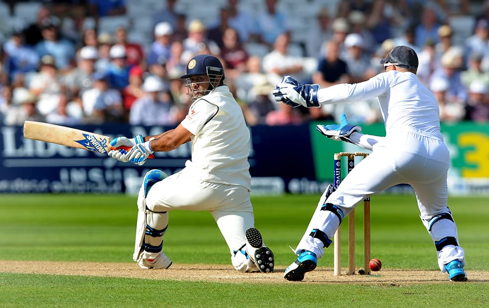 India's M.S. Dhoni, left, plays a shot past England wicket keeper Matt Prior during day one of the first Test between England and India at Trent Bridge cricket ground, Nottingham