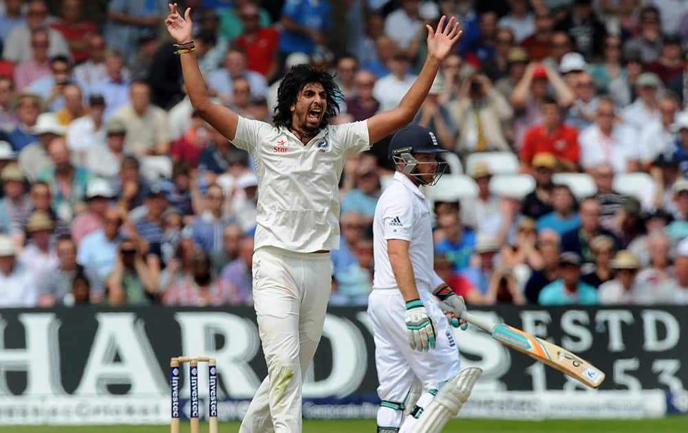 Ishant Sharma celebrates after bowling England's Ian Bell, right, caught M S Dhoni for 25 runs during day three of the first Test between England and India at Trent Bridge cricket ground, Nottingham, England.