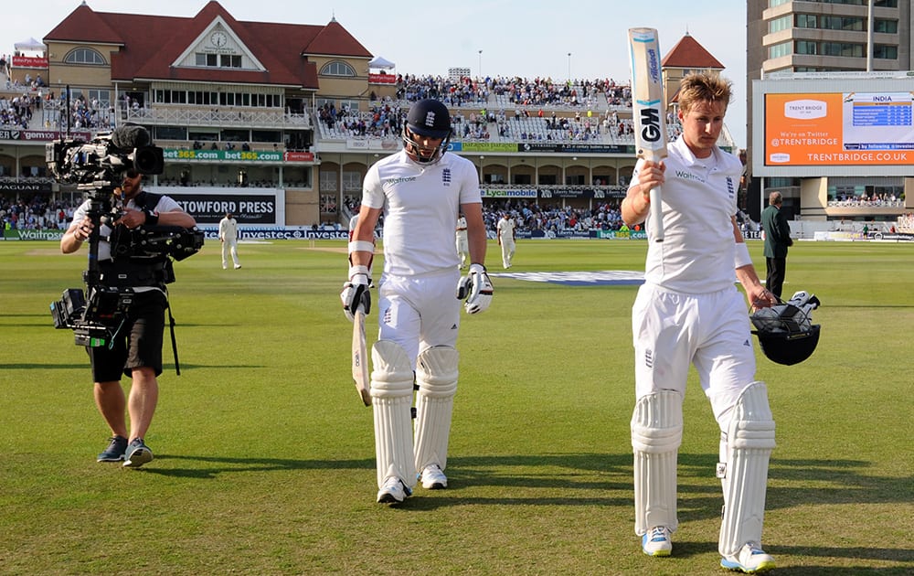 England's James Anderson, left, and Joe Root walk back to the pavilion at the end of play finishing 23 and 78 not out respectively during day three of the first Test between England and India at Trent Bridge cricket ground, Nottingham, England