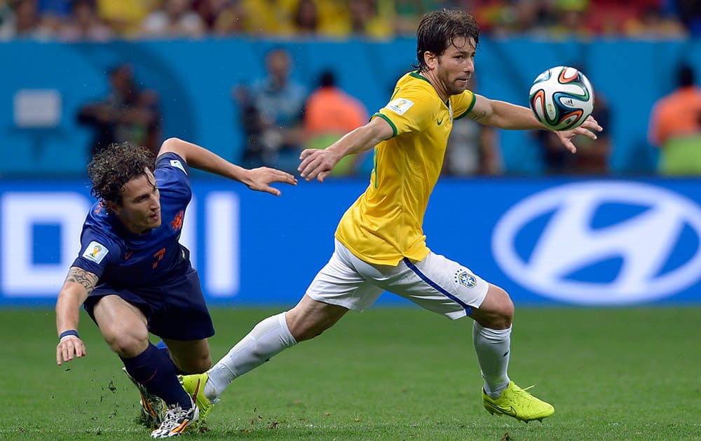 Brazil's Maxwell, right, gets away from Netherlands' Daryl Janmaat during the World Cup third-place soccer match between Brazil and the Netherlands at the Estadio Nacional in Brasilia, Brazil.