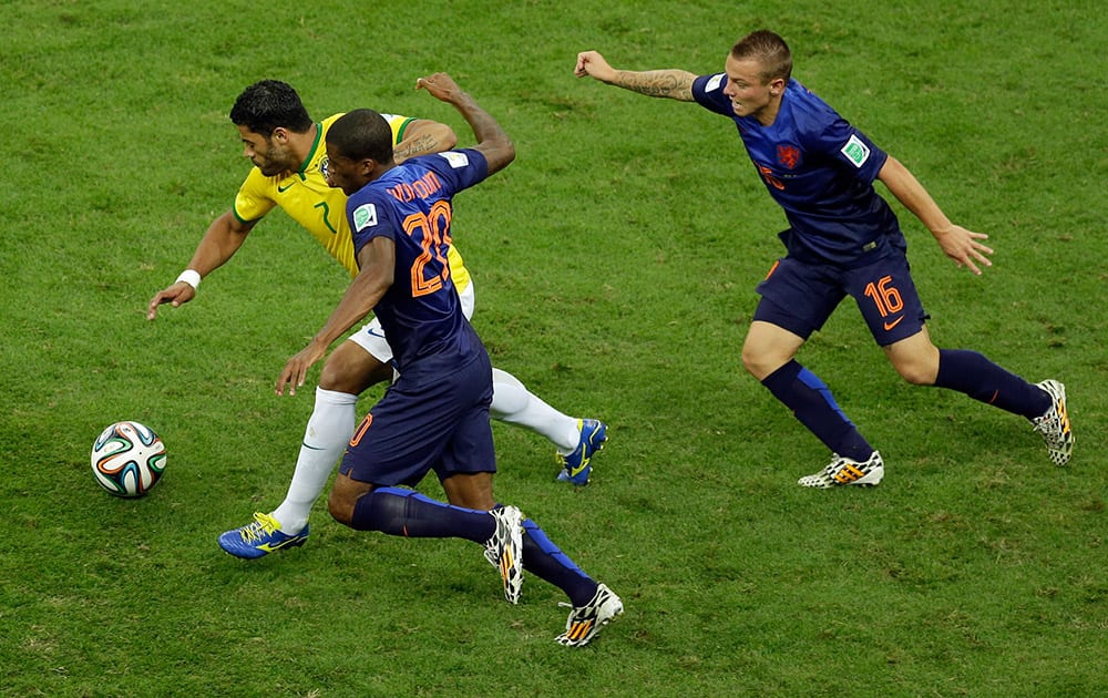 Brazil's Hulk dribbles past Netherlands' Georginio Wijnaldum during the World Cup third-place soccer match between Brazil and the Netherlands at the Estadio Nacional in Brasilia, Brazil.