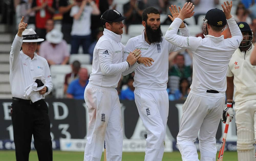 England's Moeen Ali, 2nd left, celebrates with Ian Bell and Gary Ballance, right, after bowling India's Murali Vijay caught Matt Prior for 52 runs during day four of the first Test between England and India at Trent Bridge cricket ground, Nottingham, England.