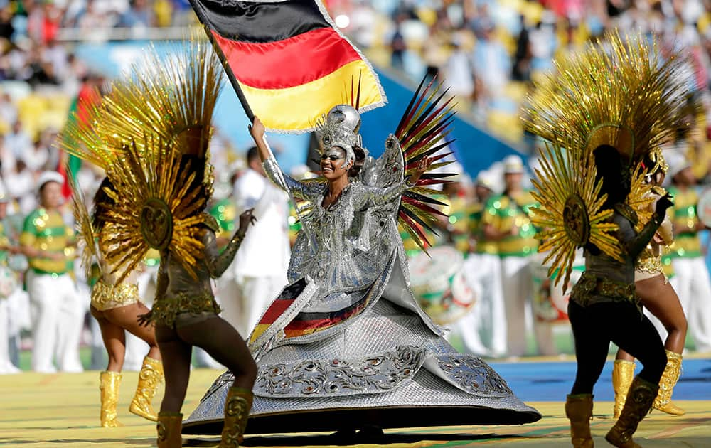 A performer waves the German flag during the closing ceremony before the World Cup final soccer match between Germany and Argentina at the Maracana Stadium in Rio de Janeiro.