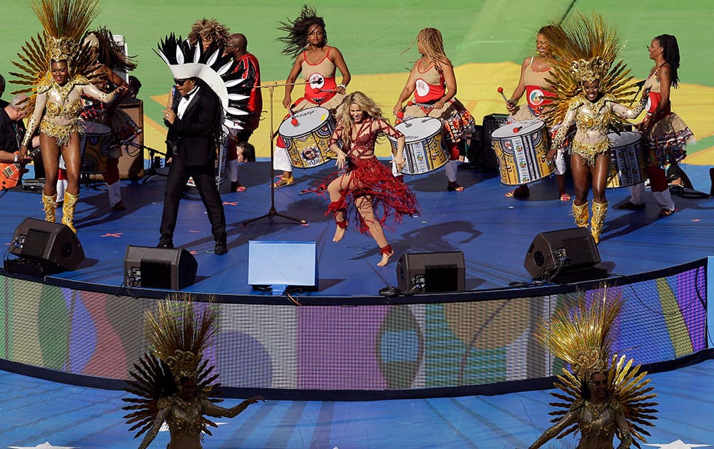 Colombian pop star Shakira, center in red, performs during the closing ceremony before the World Cup final soccer match between Germany and Argentina at the Maracana Stadium in Rio de Janeiro, Brazil.