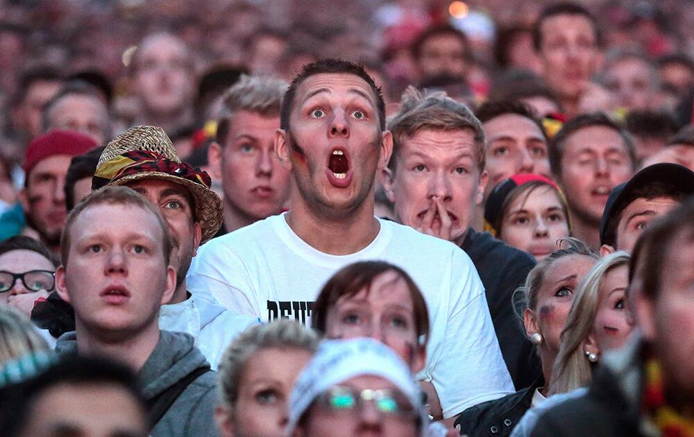 German fans react as they watch a live broadcast of the final match between Germany and Argentina at the soccer World Cup 2014 in Rio de Janeiro, Brazil, at a public viewing area called 'Fan Mile' in Berlin.