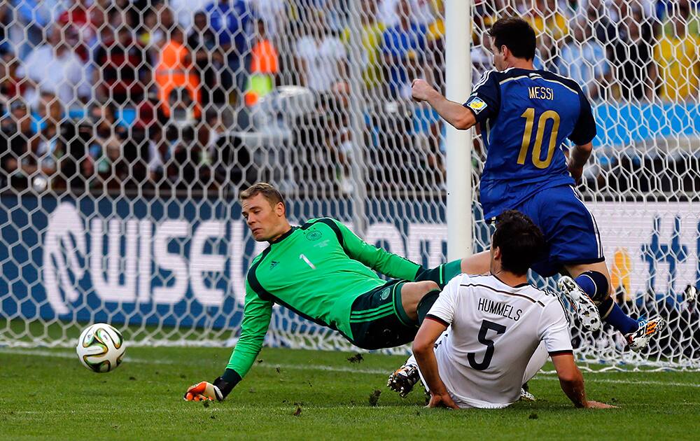 Germany's goalkeeper Manuel Neuer, left, deflects a ball by Argentina's Lionel Messi, right, during the World Cup final soccer match between Germany and Argentina at the Maracana Stadium in Rio de Janeiro