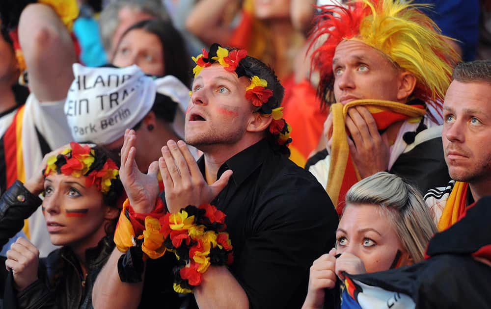 German soccer fans react as they watch a live broadcast of the final match between Germany and Argentina at the soccer World Cup 2014 in Rio de Janeiro, Brazil.