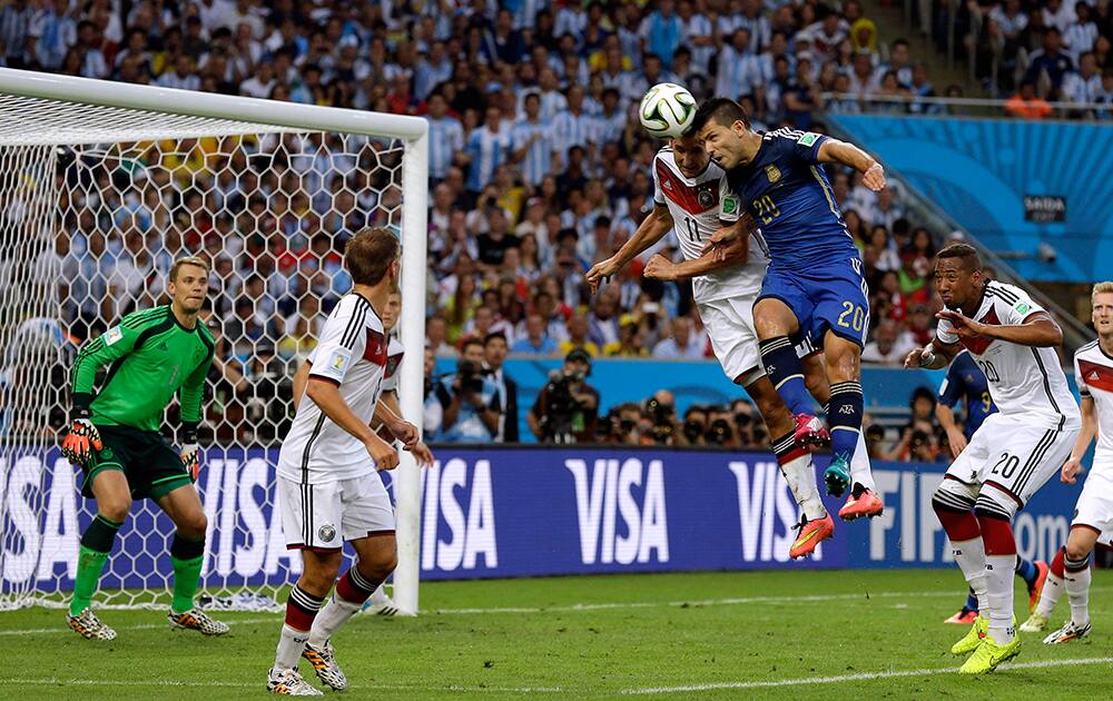 Argentina's Sergio Aguero, second right, and Germany's Miroslav Klose go for a header during the World Cup final soccer match between Germany and Argentina at the Maracana Stadium in Rio de Janeiro, Brazil.