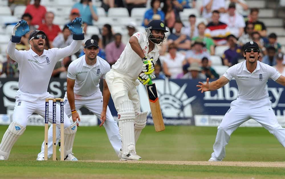 England's Matt Prior, left, James Anderson and Alastair Cook react as India's Ravindra Jadeja as plays a shot, during day five of the first Test between England and India at Trent Bridge cricket ground, Nottingham