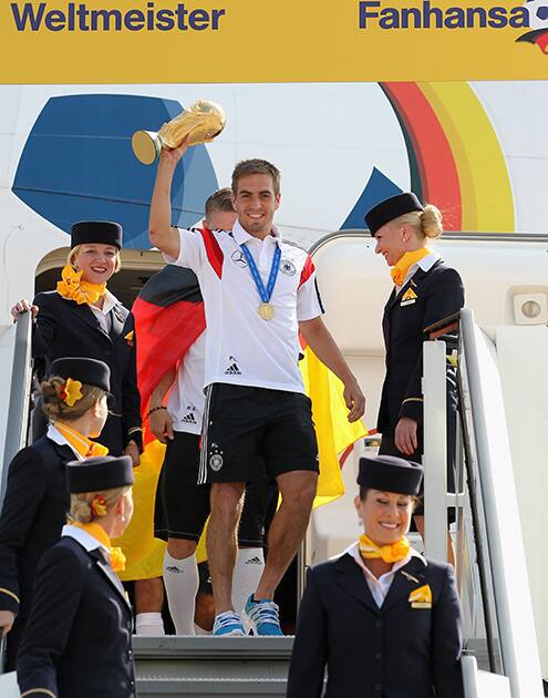 Germany's Philipp Lahm lifts the trophy at the the arrival of the German national soccer team from Brazil at Tegel airport in Berlin.