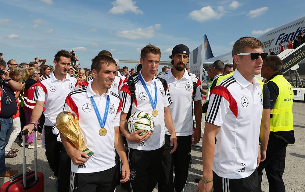 German national soccer players from left : Miroslav Klose, Philipp Lahm, Lars Bender, Sami Khedira and Toni Kroos arrive with the team at Tegel airport in Berlin.