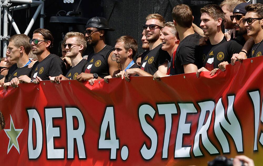 Germany players hold a poster reading 'the fourth star' during a fan party after the arrival of the German national soccer team in Berlin.