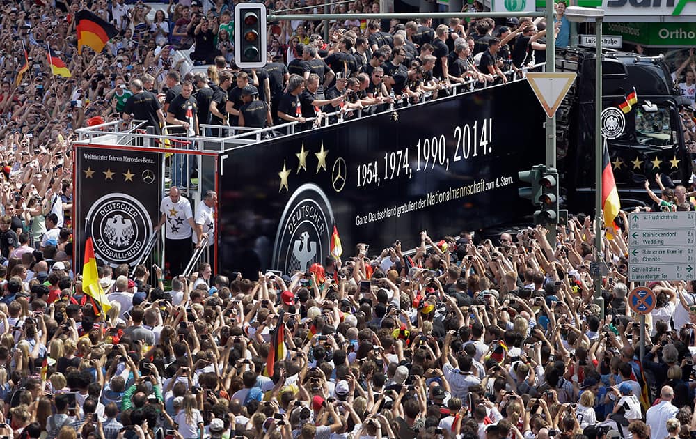 Members of the German soccer squad wave to fans after the arrival of the German national soccer team in Berlin.