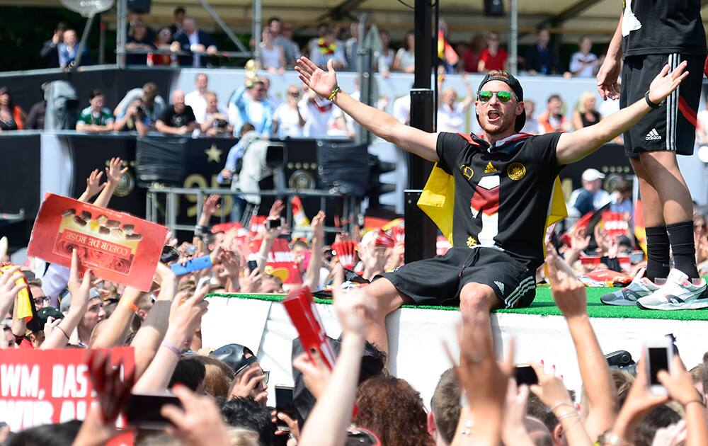 Benedikt Hoewedes celebrates during a fan party after the arrival of the German national soccer team in Berlin.