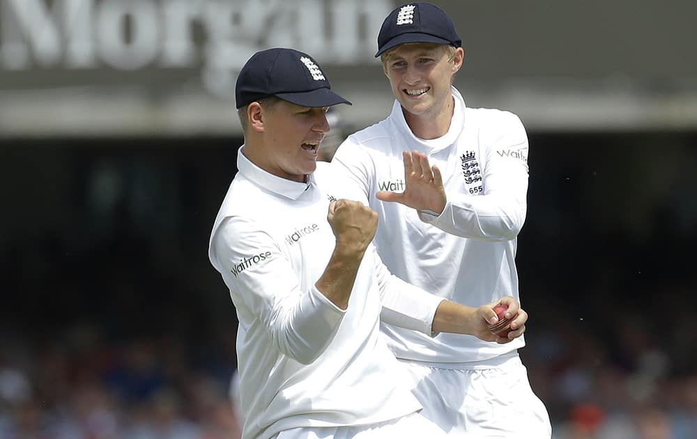 England's Gary Ballance and Joe Root celebrates catching out India's Murali Vijay during the first day of the second test match between England and India at Lord's cricket ground in London.