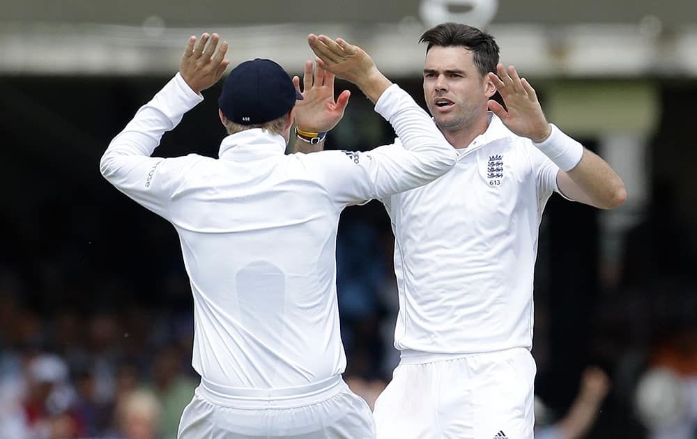 England's James Anderson and Joe Root celebrate the wicket of India's Virat Kohli during the first day of the second test match between England and India at Lord's cricket ground in London.