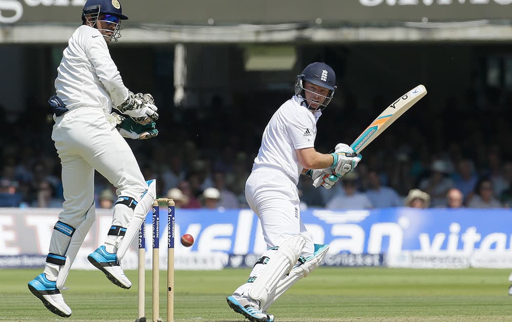 England's Ian Bell plays a shot off the bowling of India's Bhuvneshwar Kumar as wicket keeper M S Dhoni jumps during the second day of the second test match between England and India at Lord's cricket ground in London.