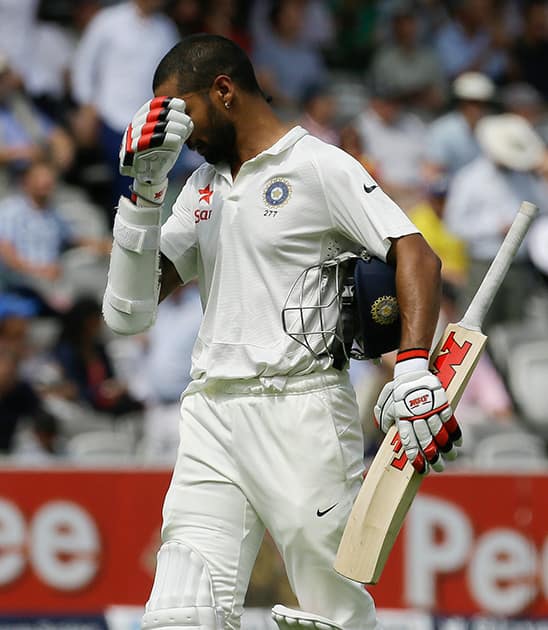 India's Shikhar Dhawan leaves the field after being caught by Joe Root off the bowling of England's Ben Stokes during the third day of the second test match between England and India at Lord's cricket ground in London.