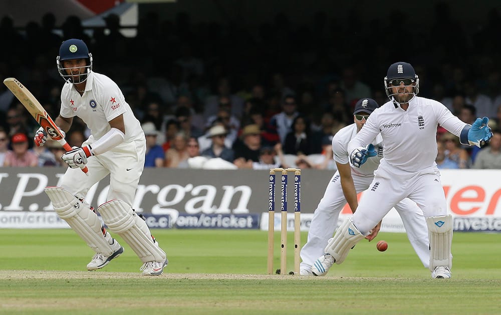 India's Cheteshwar Pujara plays a shot off the bowling of England's Moeen Ali, wicket keeper Matt Prior, right, during the third day of the second test match between England and India at Lord's cricket ground in London.