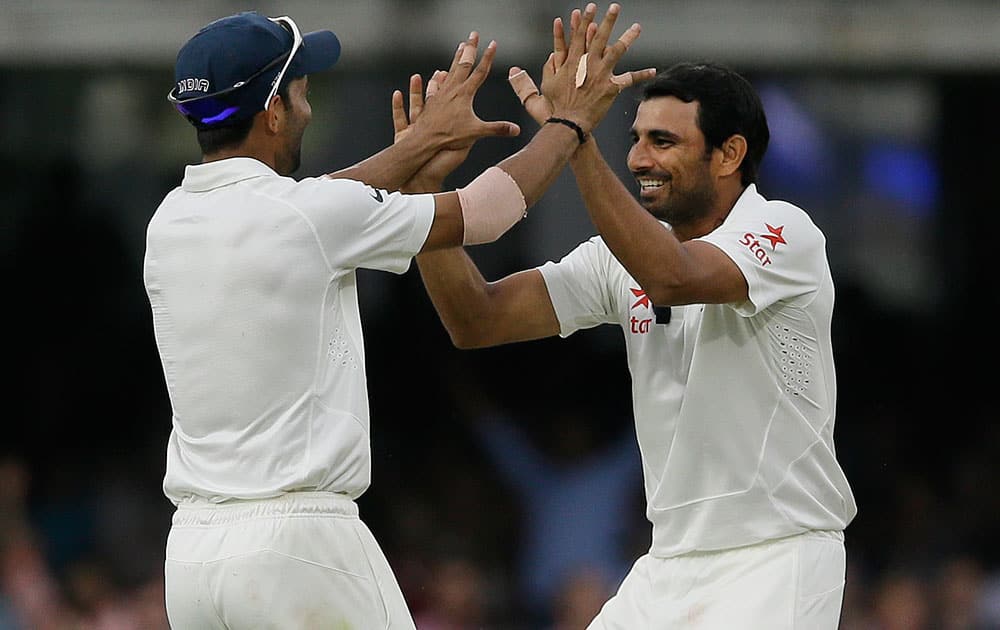 India's Mohammed Shami, right, celebrates with Ajinkya Rahane the wicket of England's Gary Ballance during the fourth day of the second test match between England and India at Lord's cricket ground in London.