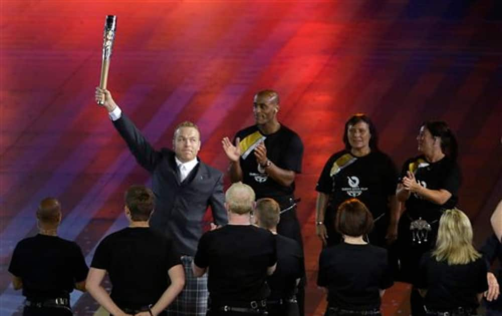 Sir Chris Hoy holds up the Queen's baton during the opening ceremony for the Commonwealth Games 2014 in Glasgow.