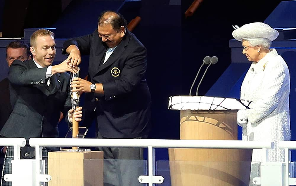 Britain's Queen Elizabeth II looks on as British former Olympian cyclist Chris Hoy, left, and Prince Tunku Imran of Malaysia, president of the Commonwealth Games Federation struggle to open the Queen's baton during the opening ceremony for the Commonwealth Games 2014 in Glasgow, Scotland.