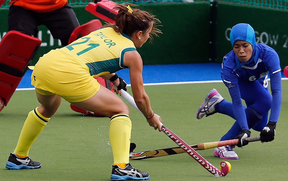 Australia's Jayde Taylor left , and Malaysia's Raja Norsharina Raja Shabuddin challenge for the ball during the hockey match between Australia and Malaysia at the Commonwealth Games 2014 in Glasgow, Scotland.