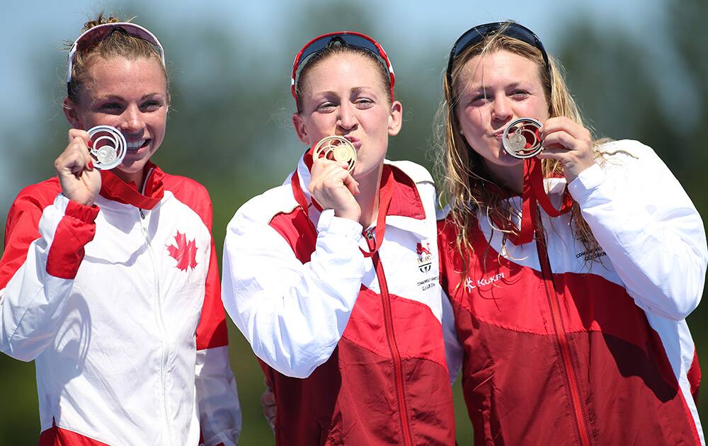 Medal winners of the women's Triathlon race, gold medal winner Jodie Simpson, England, centre, silver medal winner Kirsten Sweetland Canada, left, and bronze medal winner Vicky Holland display their medals following the Triathlon race at the Commonwealth Games Glasgow 2014, Strathclyde Country Park.