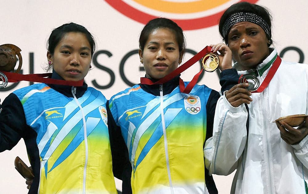 India's gold medalist Sanjita Khumukcham and compatriot silver medallist Chanu Saikhom with bronze medalist Nigeria Opara Nkechi during the medal presentation ceremony of 48-kg women's weightlifting event at the Commonwealth Games in Glasgow, Scotland.