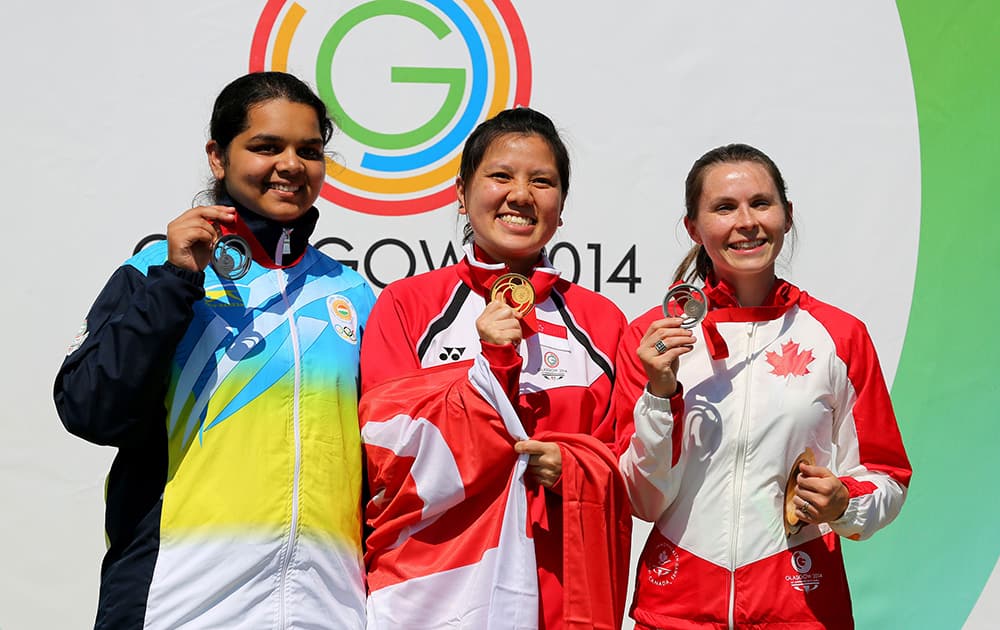 Singapore's Shun Xie Teo celebrates winning the Gold Medal in the final of the 10m Air Pistol Women with silver medalist India's Malaika Goel and bronze medalist Canada's Dorothy Ludwig, during the Glasgow 2014 Commonwealth Games at the Barry Buddon Shooting Centre in Carnoustie.