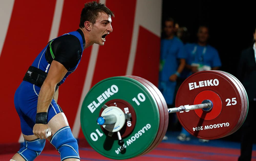 Dimitris Minasidis, of Cyprus shouts out as he drops the weights after a successful lift during the men's 62 weightlifting contest at the Commonwealth Games Glasgow 2014, in Glasgow, Scotland.