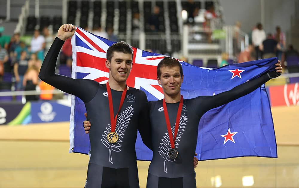 New Zealand's gold medallist Thomas Scully celebrates on the podium with countryman bronze medallist Aaron Gate, right, after the 40km points race final in the Chris Hoy velodrome during the Commonwealth Games Glasgow 2014, Scotland.