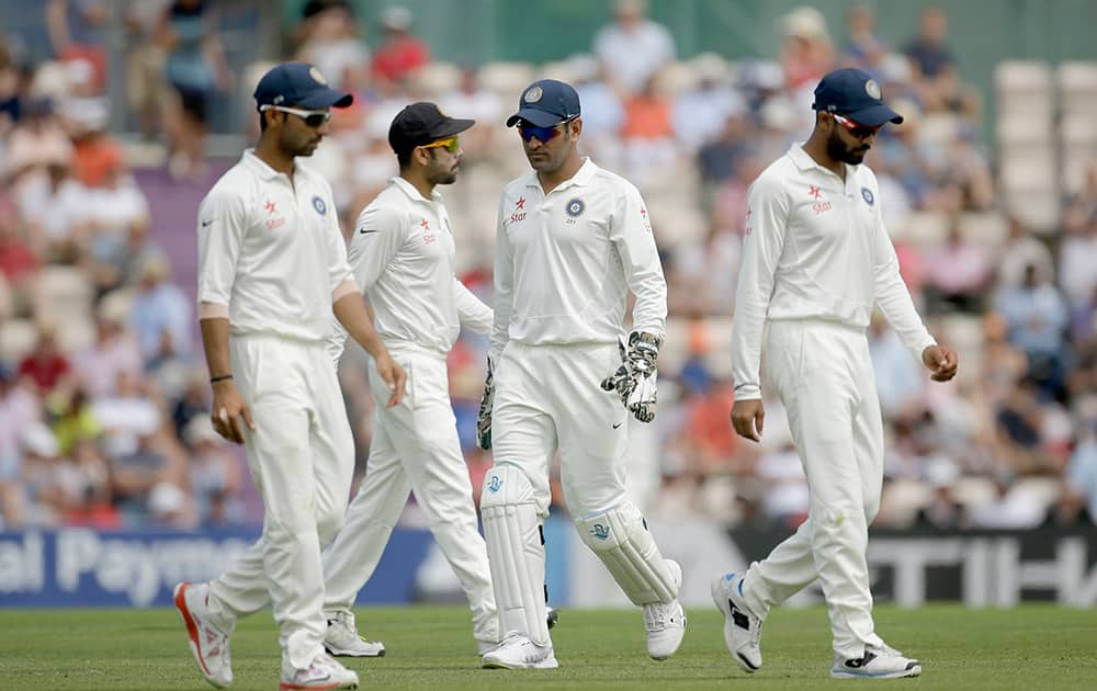 India's captain and wicketkeeper Mahendra Singh Dhoni, third left, and his slips move to their fielding positions during the first day of the third cricket test match of the series between England and India at The Ageas Bowl in Southampton, England.