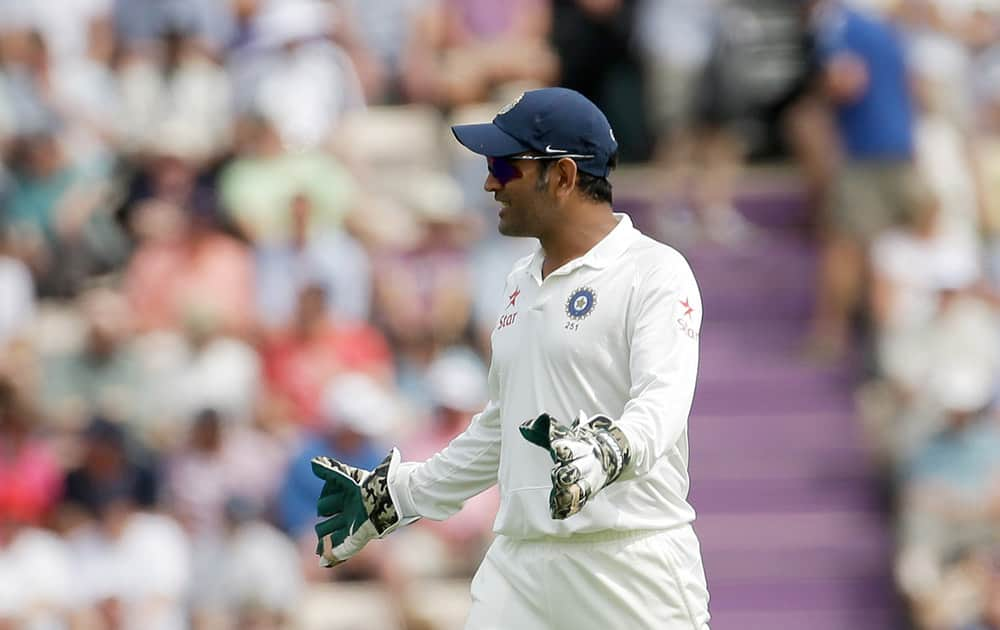 India's captain and wicketkeeper Mahendra Singh Dhoni gives a teammate fielding instructions during the first day of the third cricket test match of the series between England and India at The Ageas Bowl in Southampton, England.