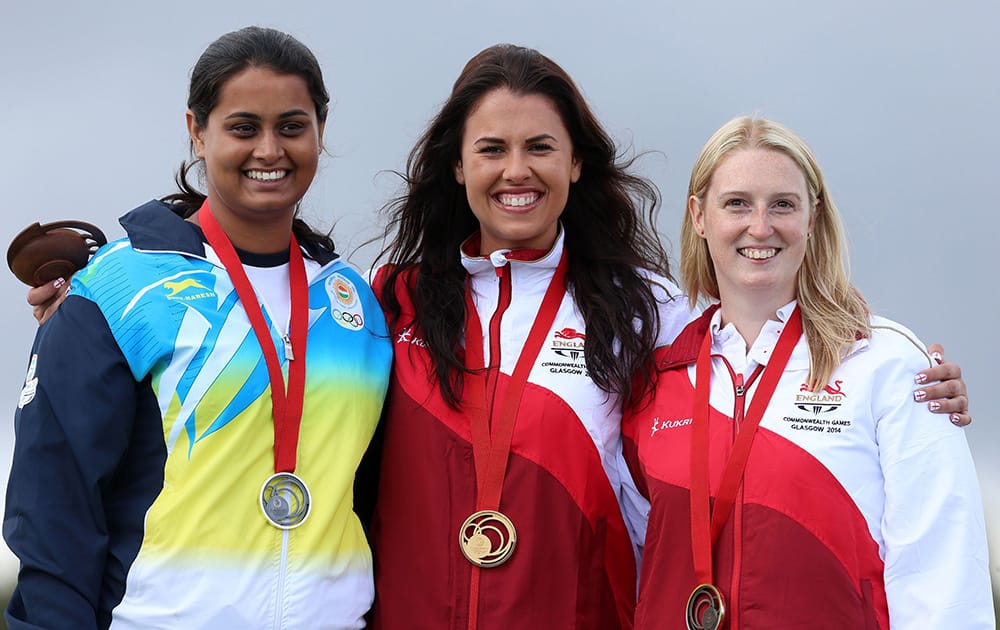 England's gold medallist Charlotte Kerwood, center, celebrates on the podium with silver medalist India's Shreyasi Singh, left, and bronze medallist England's Rachel Parish following the Women's Double Trap at the Barry Buddon Shooting Centre in Carnoustie, Scotland, during the Glasgow 2014 Commonwe