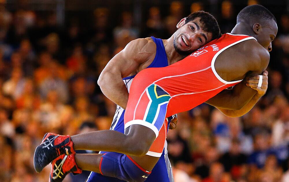 Amit Kumar Amit of India, left, wrestles with Bokang Masunyane of South Africa in an FS 57kg quarterfinal match at the Scottish Exhibition Conference Centre during the Commonwealth Games 2014 in Glasgow.