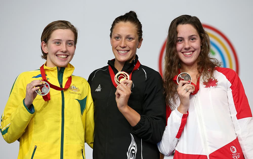 New Zealand's Sophie Pascoe holds her gold medal, center, with Australia's silver medalist Katherine Downie, left, and Canada's bronze medalist Aurelie Rivard after the Women's 200m Ind. Medley SM10 Final, at Tollcross International Swimming Centre, during the 2014 Commonwealth Games.