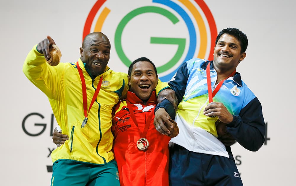 Gold medal winner Steven Kukuna Kari, attempts to lift silver medalist Simplice Ribouem and bronze medalist Chandrakant Dadu Mali of India, during the medal ceremony for the men's 94kg weightlifting competition at the Scottish Exhibition Conference Centre during the Commonwealth Games.