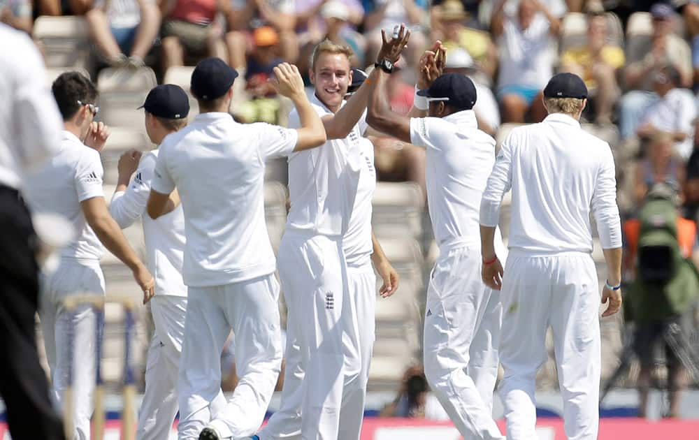 England's Stuart Broad, center, celebrates with his teammates after taking the wicket of India's Cheteshwar Pujara during the third cricket Test match of the series between England and India at The Ageas Bowl in Southampton, England.