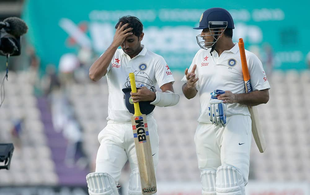 Mahendra Singh Dhoni, right, and Mohammed Shami walk off the field of play at the end of play on the third day of the third cricket test match of the series between England and India at The Ageas Bowl in Southampton.