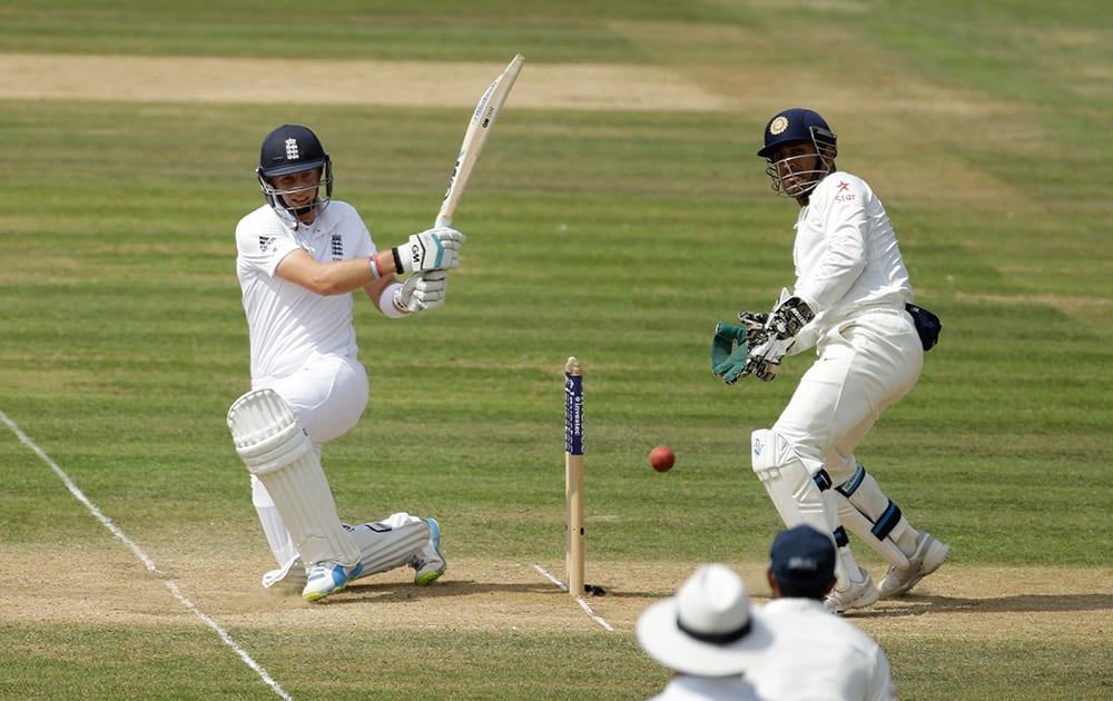 England's Joe Root hits a shot watched by India's captain and wicketkeeper Mahendra Singh Dhoni during the fourth day of the third cricket Test match of the series between England and India at The Ageas Bowl in Southampton, England.