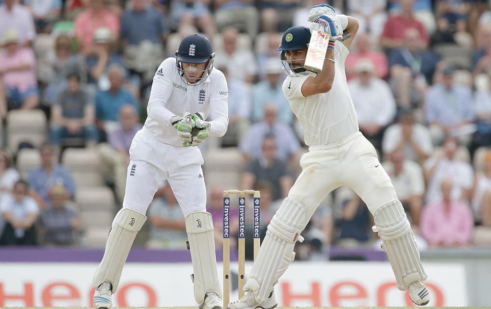 Virat Kohli hits a shot watched by test debutant England wicketkeeper Jos Buttler during the fourth day of the third cricket test match of the series between England and India at The Ageas Bowl in Southampton