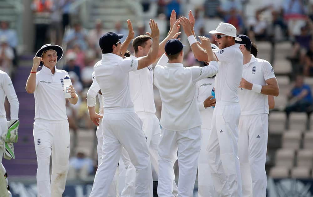 England's Stuart Broad, right, celebrates with his teammates after running out India's Murali Vijay during the fourth day of the third cricket test match of the series between England and India at The Ageas Bowl in Southampton