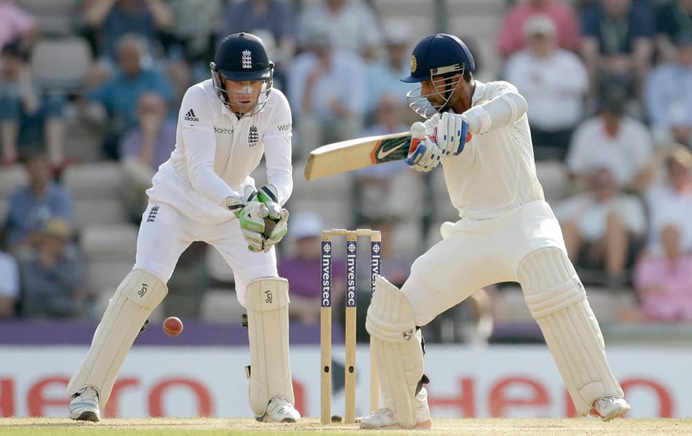 Ajinkya Rahane hits a shot watched by England test debutant wicketkeeper Jos Buttler during the fourth day of the third cricket test match of the series between England and India at The Ageas Bowl in Southampton.