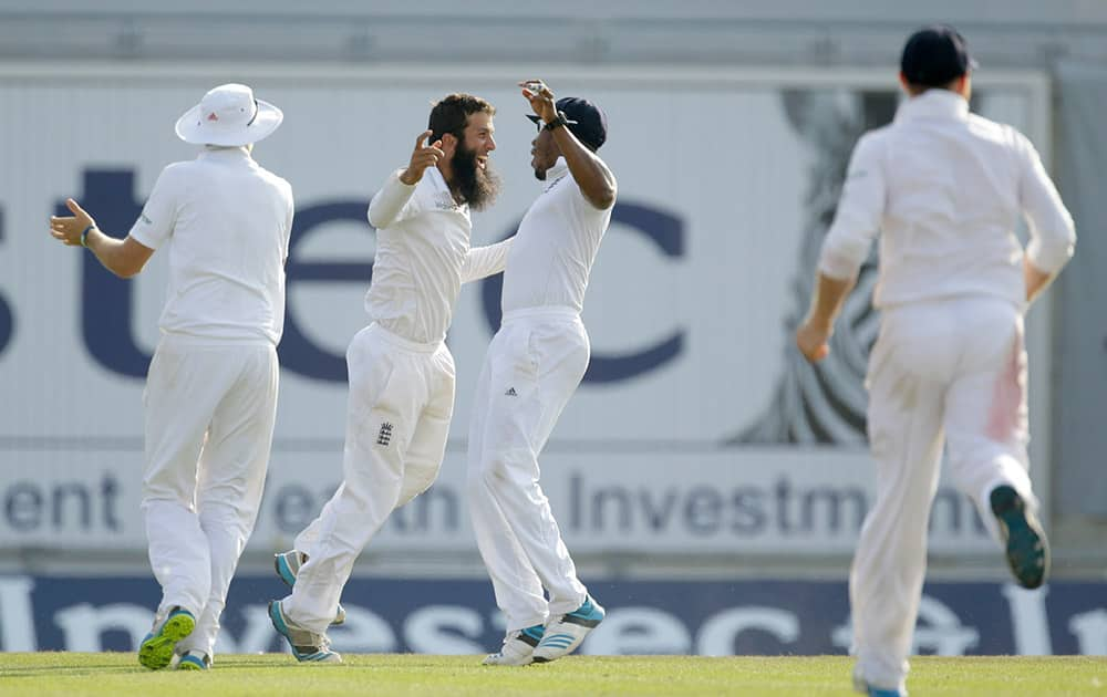 England's Moeen Ali, second left, celebrates with his teammate Chris Jordan, third left, after taking the wicket of India's Virat Kohli during the fourth day of the third cricket test match of the series between England and India at The Ageas Bowl in Southampton, England