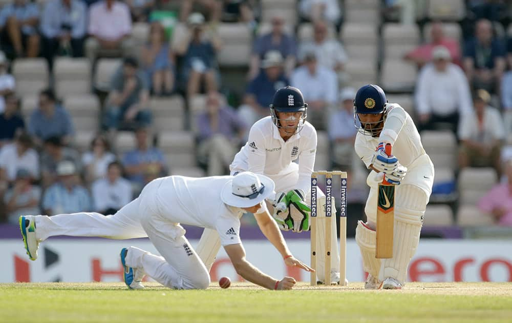 Ajinkya Rahane, right, hits a shot past England's Joe Root, left, watched by test debutant wicketkeeper Jos Buttler during the fourth day of the third cricket test match of the series between England and India at The Ageas Bowl in Southampton, England