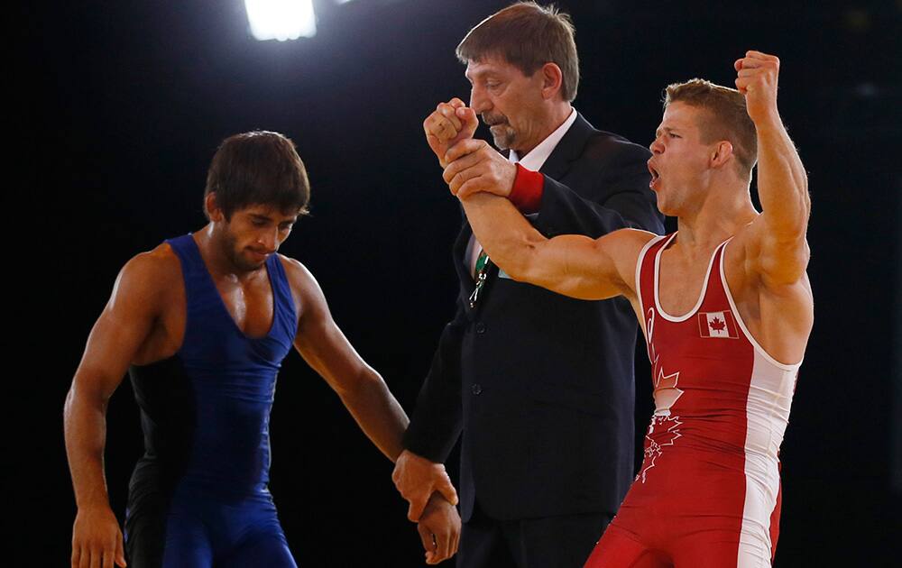 David Tremblay of Canada celebrates as the referee awards him the win defeating Bajrang Bajrang of India in their men's 61 kg gold medal wrestling bout at the Commonwealth Games Glasgow 2014, in Glasgow, Scotland.